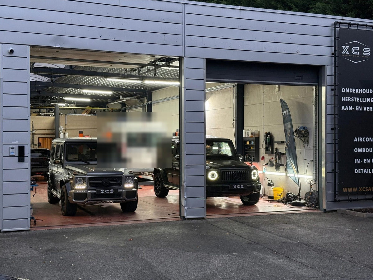 Garage XCS Automotive in Merchtem met open poorten en twee G-Klassen binnen
