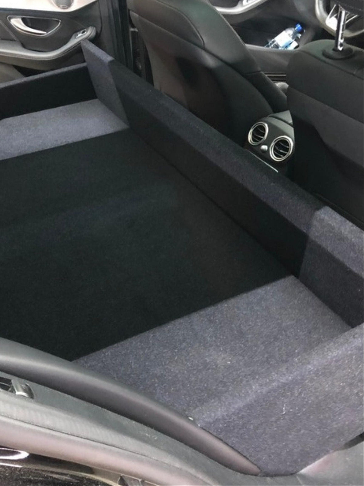Ombouw met beklede laadvloer achter de voorzetels van een wagen