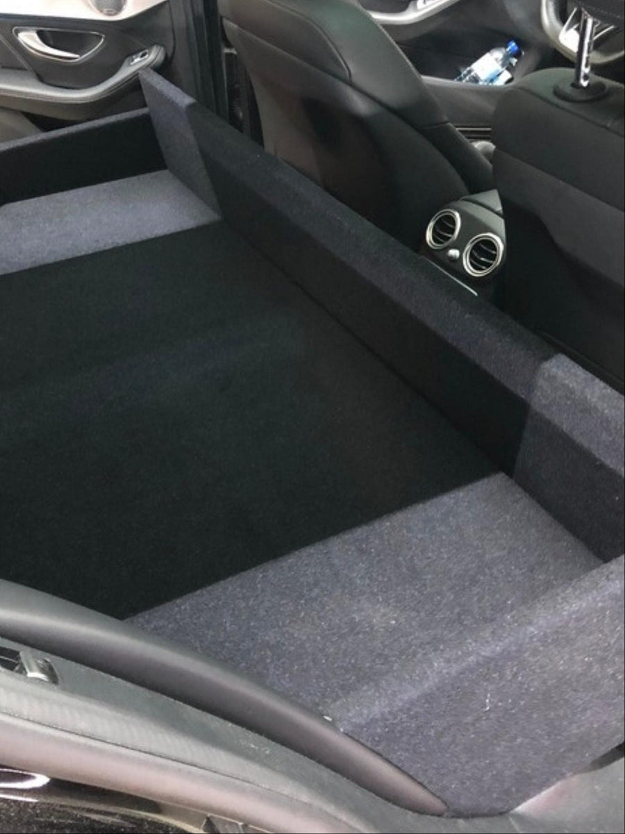 Ombouw met beklede laadvloer achter de voorzetels van een wagen