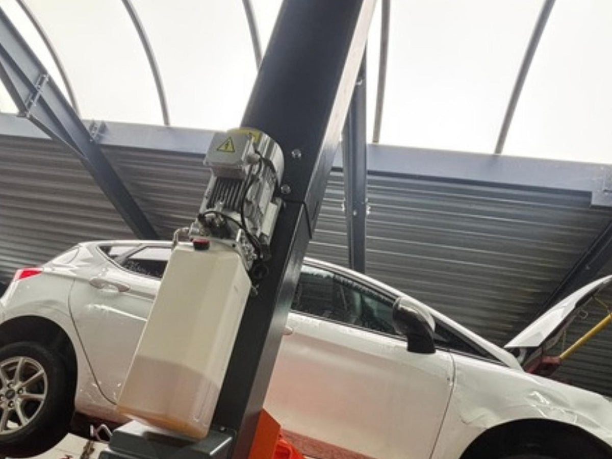 Witte wagen op de brug in de werkplaats van XCS Automotive in Merchtem