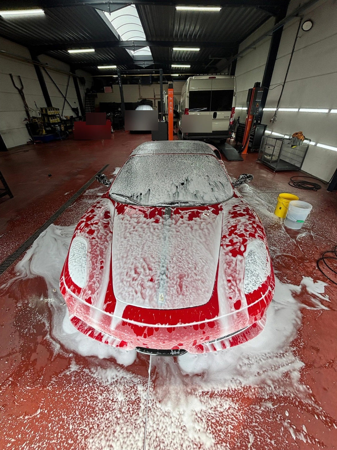 Rode Ferrari in het schuim tijdens een wasbeurt bij XCS Automotive in Merchtem