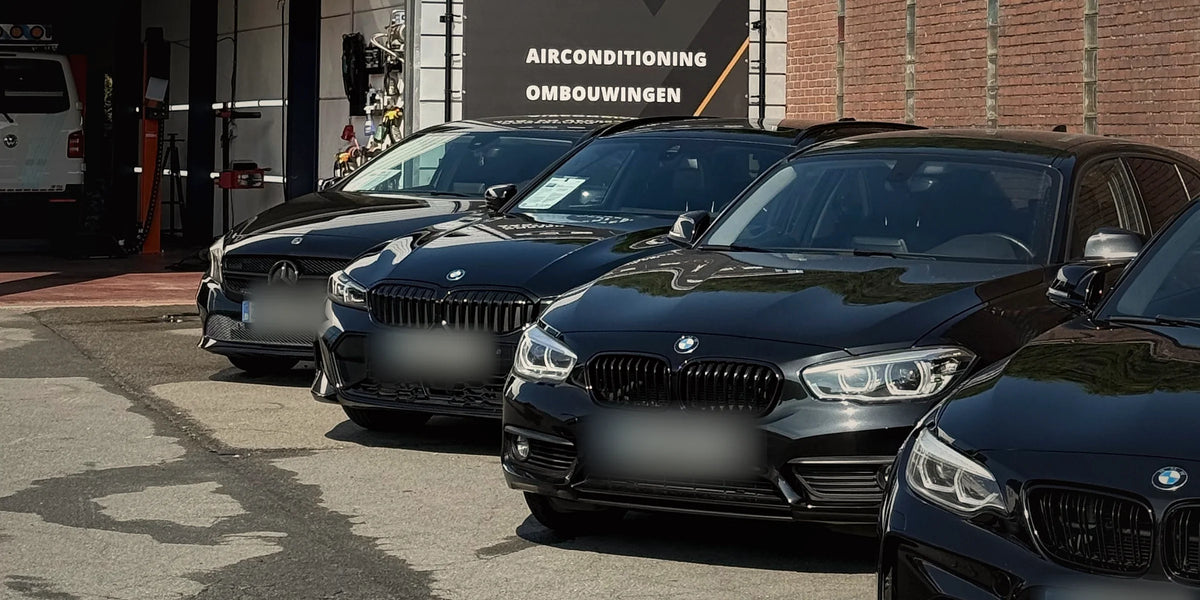 Gevel van XCS Automotive aan de Stoofstraat in Merchtem met zwarte BMW’s op de parking